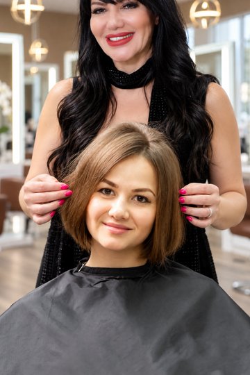 Stylist cutting a woman's bob haircut at Gloss & Glam salon in Los Angeles