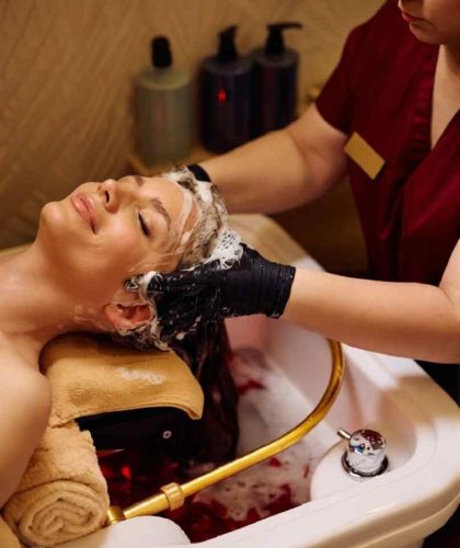 Woman getting a soothing scalp treatment for dandruff at Gloss & Glam in Los Angeles