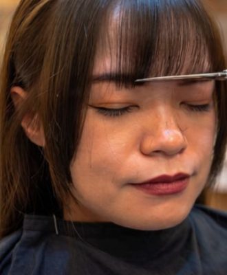 woman getting her curtain bang cut and style in Los Angeles Salon